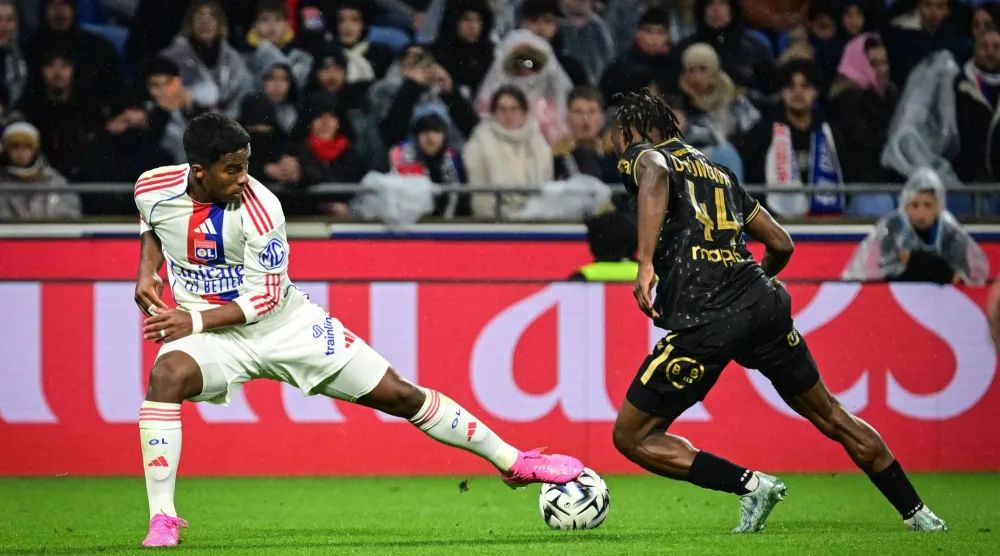 Lyon's Brazilian forward #09 Endrick (L) fights for the ball with Lorient's Cameroonian defender #44 Darlin Yongwa (R) during the French L1 football match between Olympique Lyonnais (OL) and FC Lorient at the Groupama Stadium in Decines-Charpieu, central-eastern France, on April 12, 2026. (Photo by OLIVIER CHASSIGNOLE / AFP)
