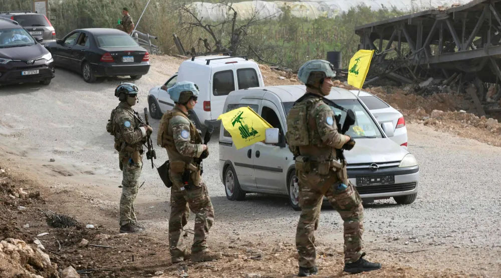 جنود فرنسيون تابعون لقوة الأمم المتحدة المؤقتة في لبنان يقفون أمام سكان يلوحون بأعلام «حزب ‌الله» في جنوب لبنان (أ.ف.ب)