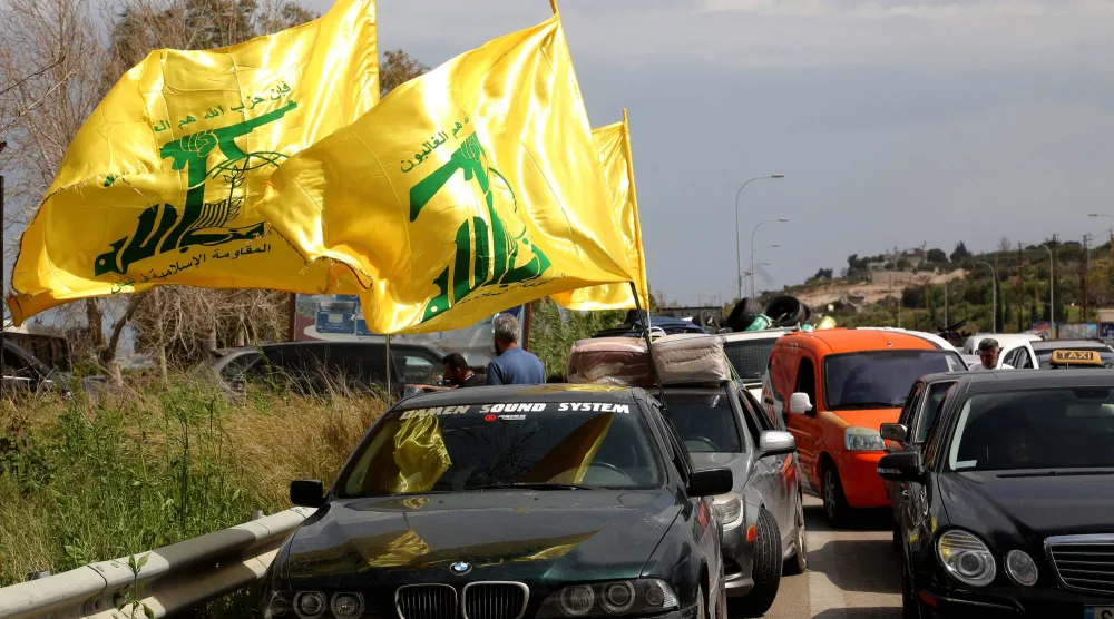 أعلام «حزب الله» ترفرف من سيارات على الطريق المؤدي إلى جنوب لبنان حيث بدأت الأسر رحلة العودة بعد وقف إطلاق النار (د.ب.أ)
