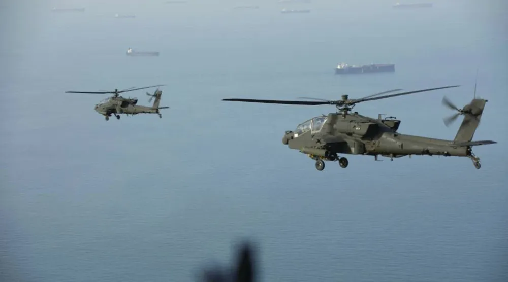 
مروحيتان هجوميتان أميركيتان من طراز «إيه إتش-64 أباتشي» تحلّقان فوق مضيق هرمز (سنتكوم)