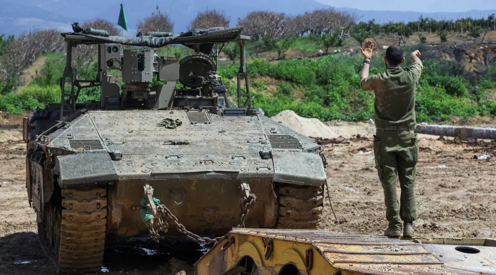 جندي إسرائيلي يوجه دبابة قرب الحدود مع لبنان (رويترز)