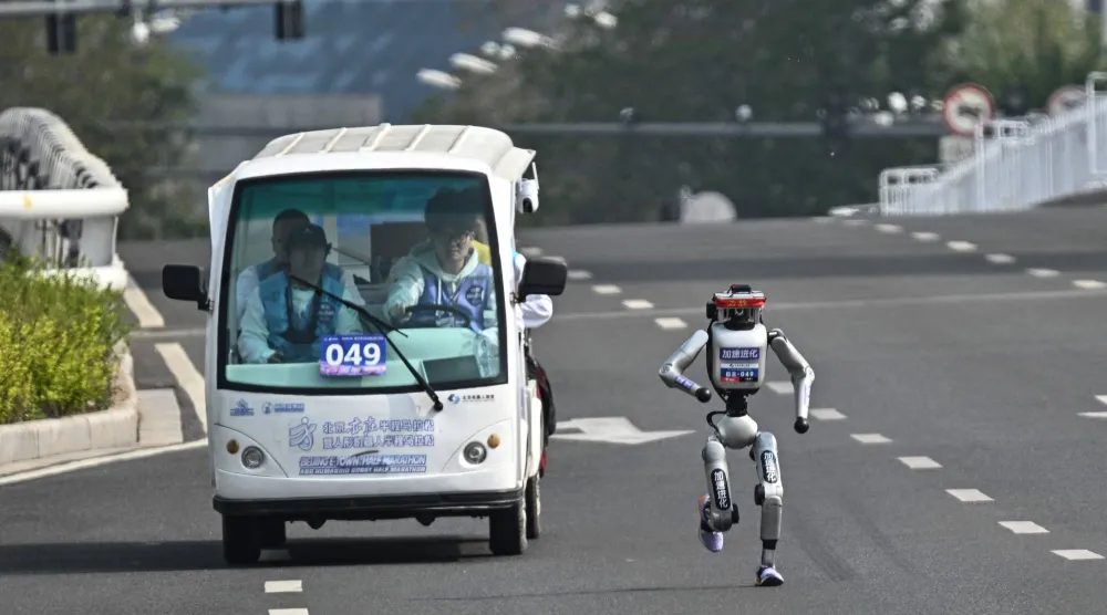 روبوت ومهندسوه خلال نصف ماراثون بكين (أ.ف.ب)