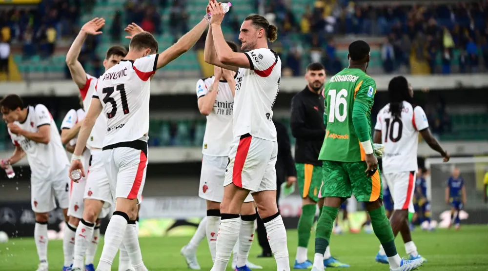 مدافع ميلان ستراهينيا بافلوفيتش ولاعب الوسط أدريان رابيو يحيّيان الجماهير عقب نهاية المباراة أمام هيلاس فيرونا (أ.ف.ب)