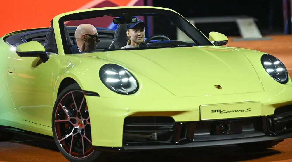  Kazakhstan's Elena Rybakina steers the winner's car next to Porsche CEO Michael Leiters after she won against Czech Republic's Karolina Muchova (not in picture) in the final match at the Women's Tennis Grand Prix WTA tournament in Stuttgart, southwestern Germany, on April 19, 2026. (AFP) 
