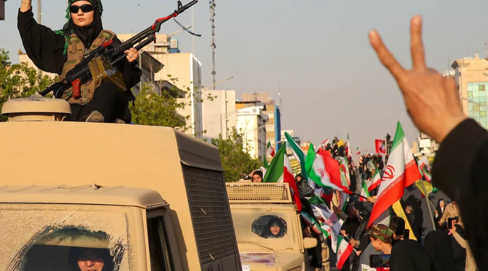 إيرانية تحمل سلاحاً خلال مسيرة في طهران الجمعة (د.ب.أ)