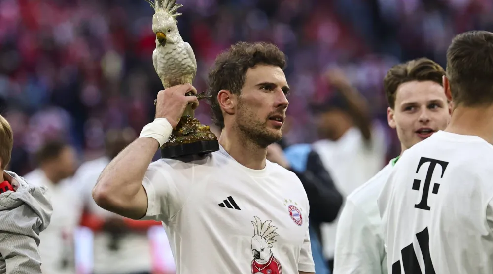 لاعب بايرن ميونيخ ليون غوريتسكا يحتفل ممسكاً بتمثال ببغاء الكوكاتو المصنوع من الخزف (أ.ف.ب)