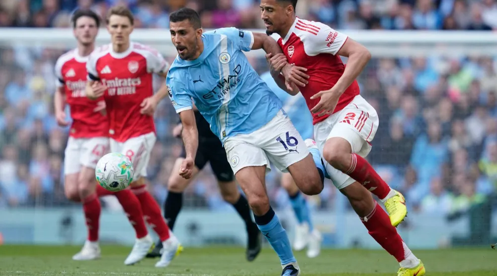 لاعب وسط مانشستر سيتي رودري يصارع على الكرة مع مدافع آرسنال ويليام ساليبا (أ.ب)