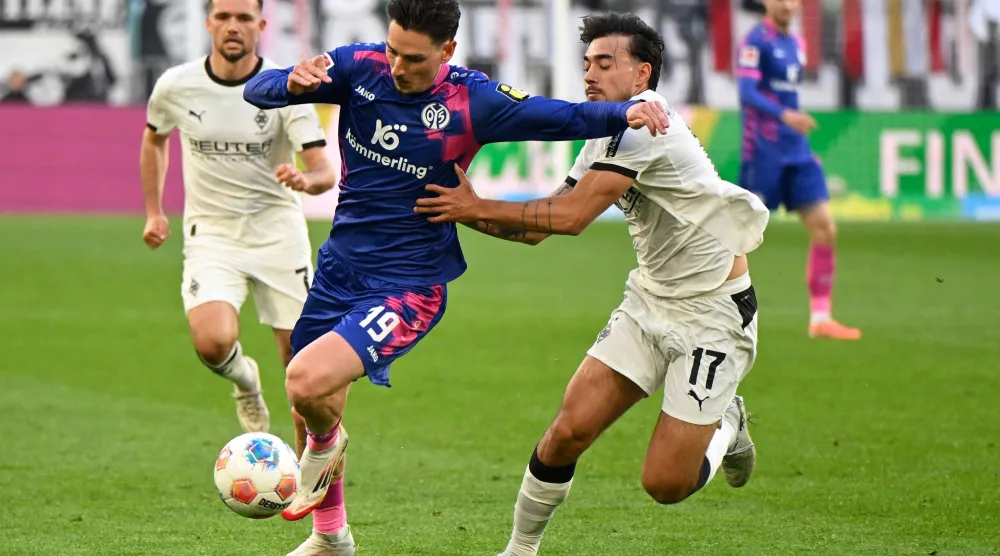 لاعب ماينز أنتوني كاتشي ولاعب بوروسيا مونشنغلادباخ ينس كاستروب يتصارعان على الكرة (د.ب.أ)