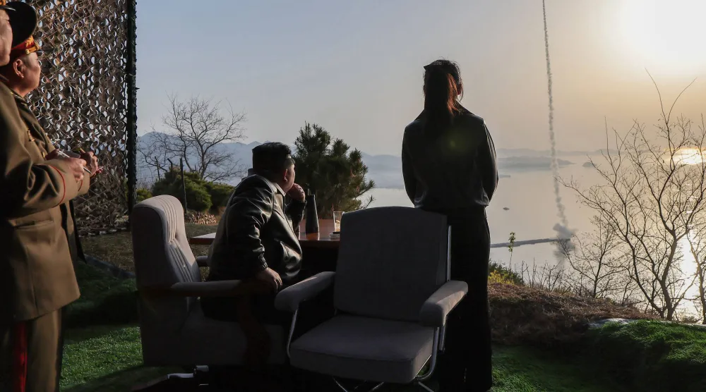 الزعيم الكوري الشمالي كيم جونغ أون (يسار) وابنته كيم جو آي (يمين) وهما يتفقدان تجربة إطلاق صاروخ باليستي في موقع لم يُكشف عنه في كوريا الشمالية (أ.ف.ب)