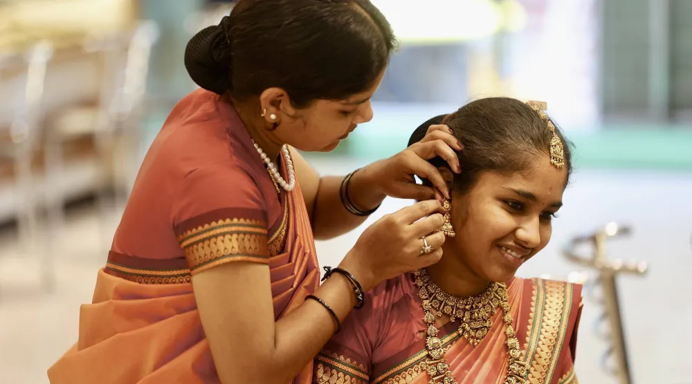 امرأة هندية ترتدي حلياً ذهبياً في متجر مجوهرات في بنغالور (إ.ب.أ)