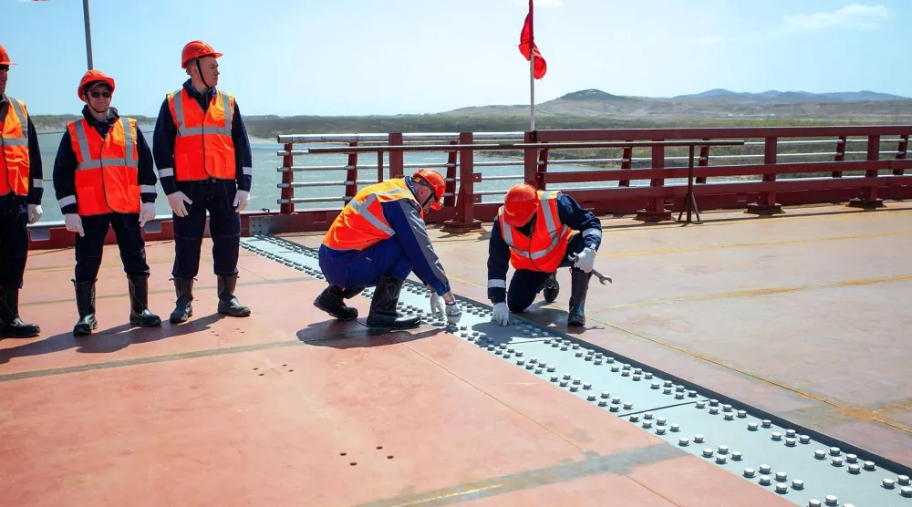 This handout image released by the Russian Transport Ministry on April 21, 2026, shows a ceremony marking the connection of the two sides of the new Russia-North Korea road bridge over the Tumen River, set to open this summer. (Handout / Russian Transport Ministry / AFP) 