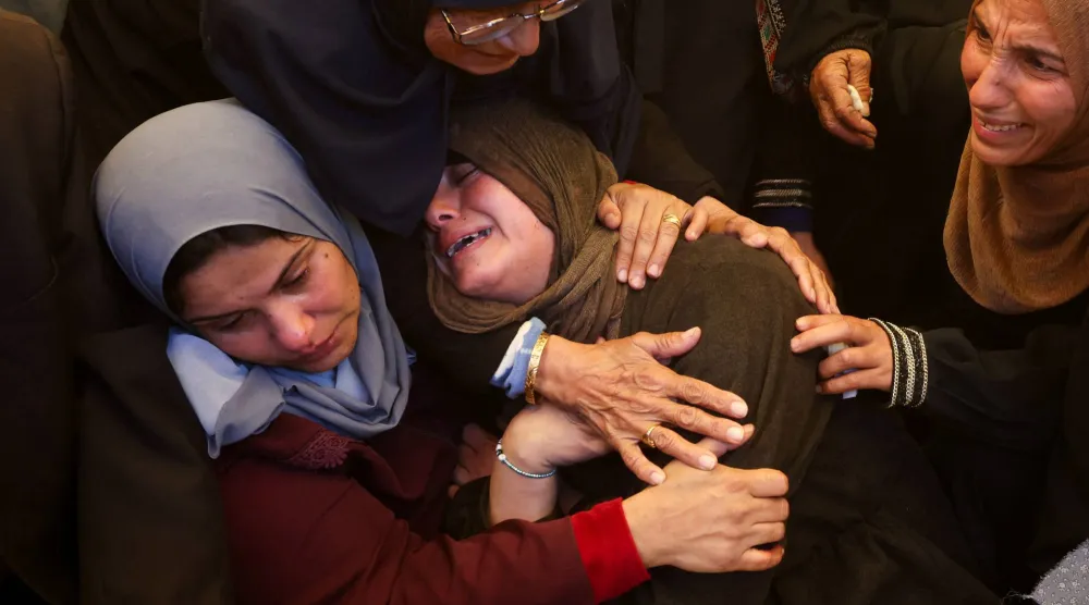 نساء يبكين خلال جنازة خميس القصاص الذي قُتل الثلاثاء في غارة جوية إسرائيلية في مستشفى ناصر بخان يونس جنوب قطاع غزة (رويترز)