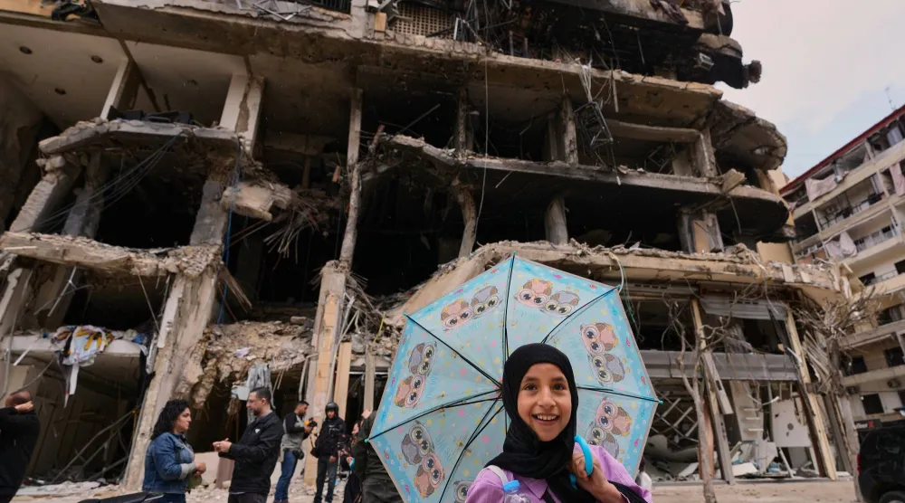 طفلة أمام مبنى تعرَّض لغارات إسرائيلية في الضاحية الجنوبية لبيروت (أ.ب)