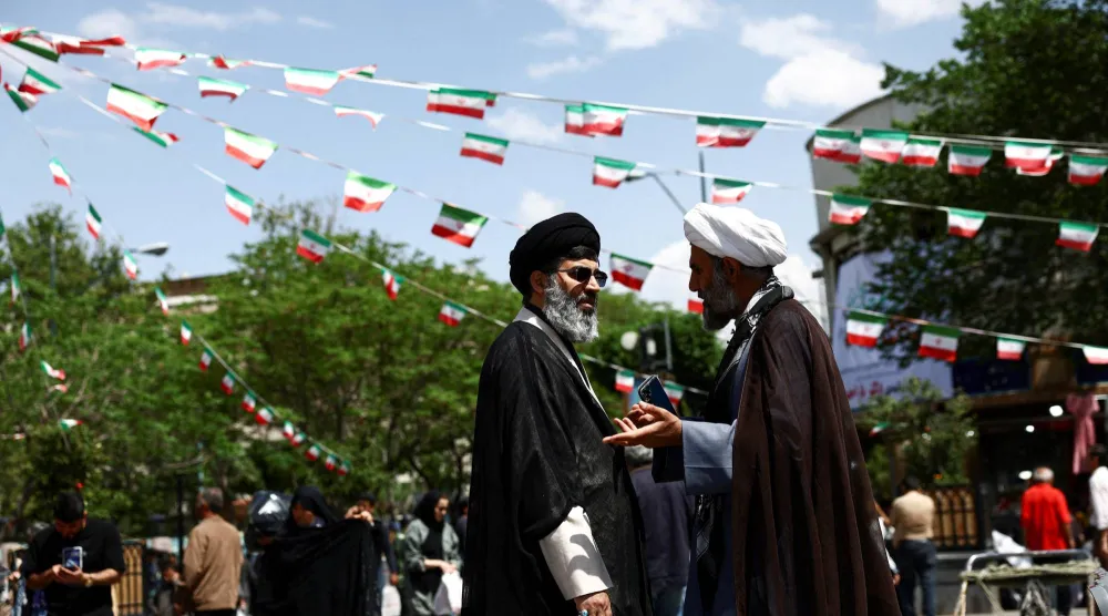 رجلا دين إيرانيان يتحدثان في بازار طهران الثلاثاء (رويترز)