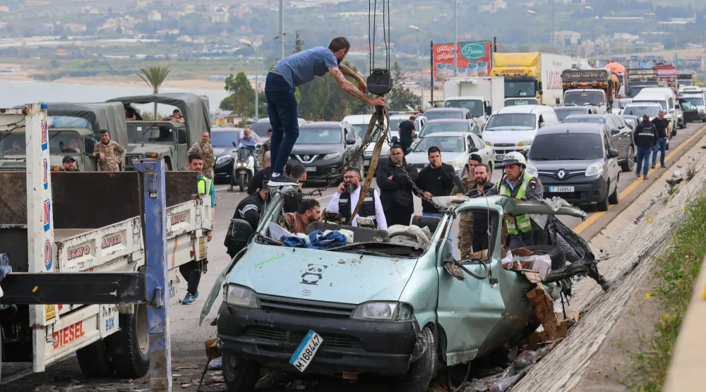 أشخاص يزيلون حطام سيارة من موقع استهدافها بغارة إسرائيلية في بلدة السعديات جنوب بيروت (أرشيفية - إ.ب.أ)