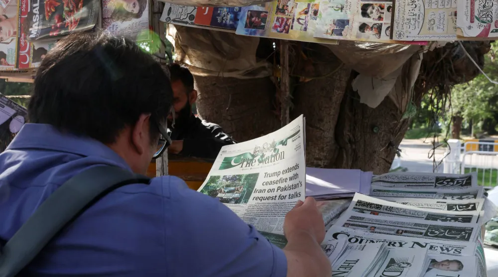 A person reads a newspaper, after US President Donald Trump said he would indefinitely extend the ceasefire with Iran, as Pakistan prepares to host the US and Iran for the second phase of peace talks in Islamabad, Pakistan April 22, 2026. REUTERS/Akhtar Soomro