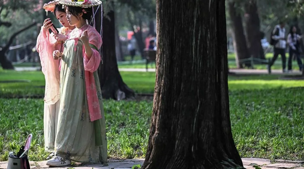 Women dressed in imperial outfits visit the Zhongshan Park during spring season in Beijing on April 18, 2026. (AFP) 