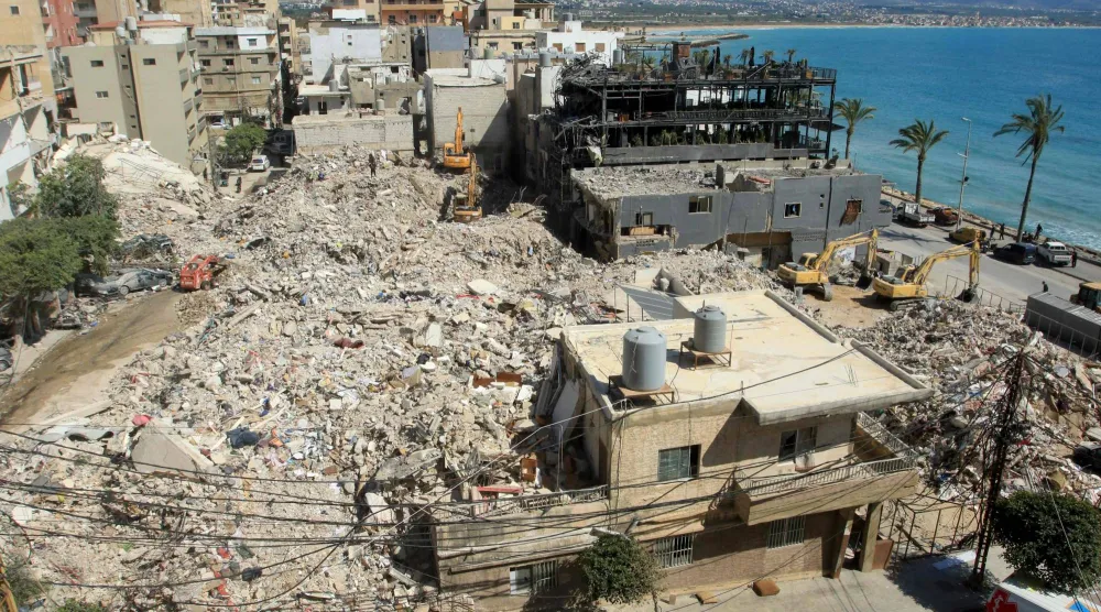 حفارات تزيل أنقاض المباني التي دمرتها الغارات الإسرائيلية بحثاً عن ناجين مدفونين تحتها في مدينة صور الساحلية جنوب لبنان (أ.ف.ب)