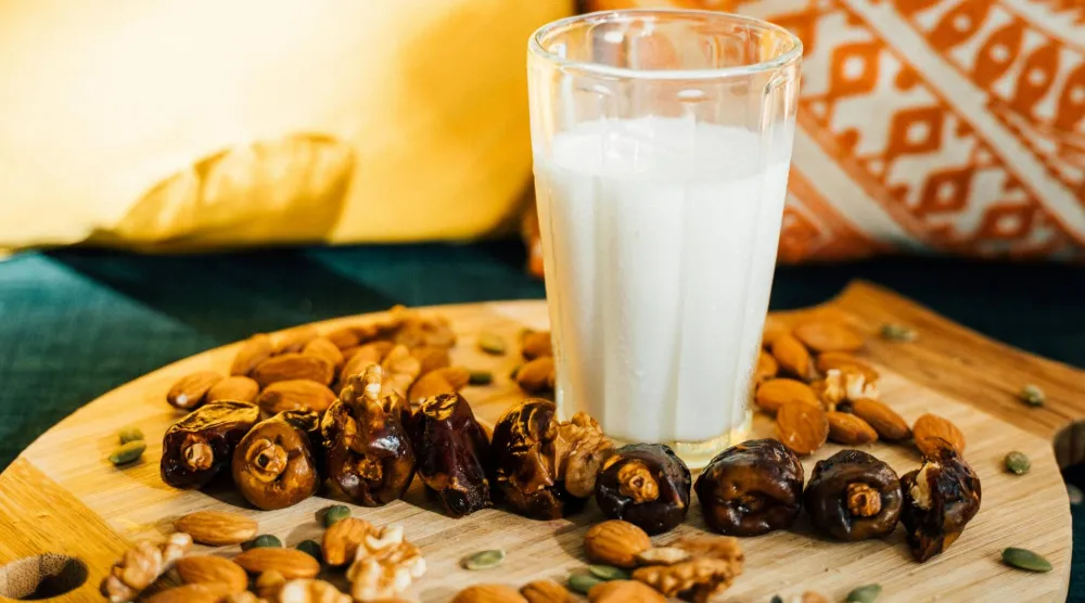 كوب من الحليب وسط مجموعة من المكسرات (بكسلز)