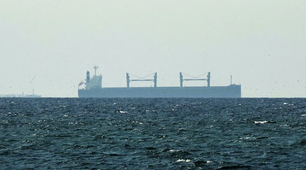 FILE PHOTO: A cargo ship in the Gulf, near the Strait of Hormuz, as seen from northern Ras al-Khaimah, near the border with Oman’s Musandam governance, amid the US-Israeli conflict with Iran, in United Arab Emirates, March 11, 2026. REUTERS