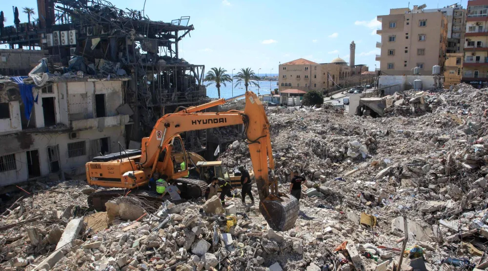 حفارة تزيل أنقاض مبانٍ دمَّرتها غارات إسرائيلية بينما يستمر البحث عن ناجين مدفونين تحت الأنقاض في مدينة صور الساحلية جنوب لبنان 21 أبريل 2026 (أ.ف.ب)