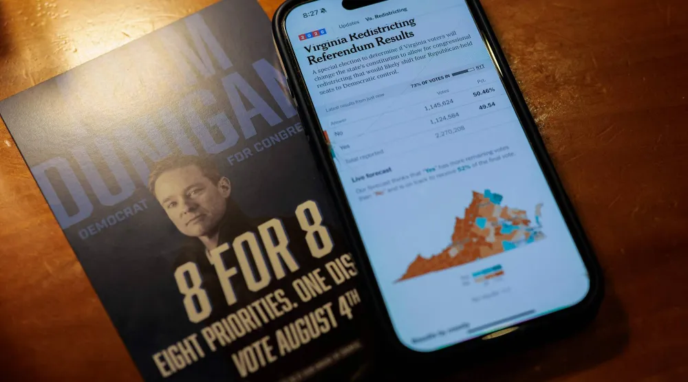 شاشة هاتف أحد السكان المحليين وفيها تحديثات حول التصويت على إعادة تقسيم الدوائر الانتخابية في فيرجينيا (أ.ف.ب)