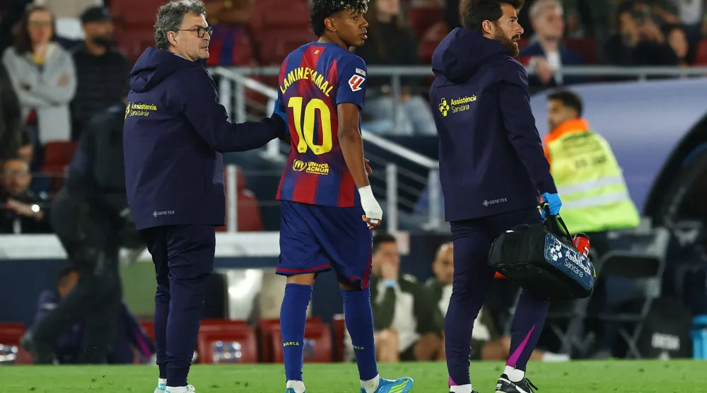 يتلقى لاعب برشلونة لامين جمال العلاج الطبي بعد تعرضه لإصابة خلال المباراة (رويترز)