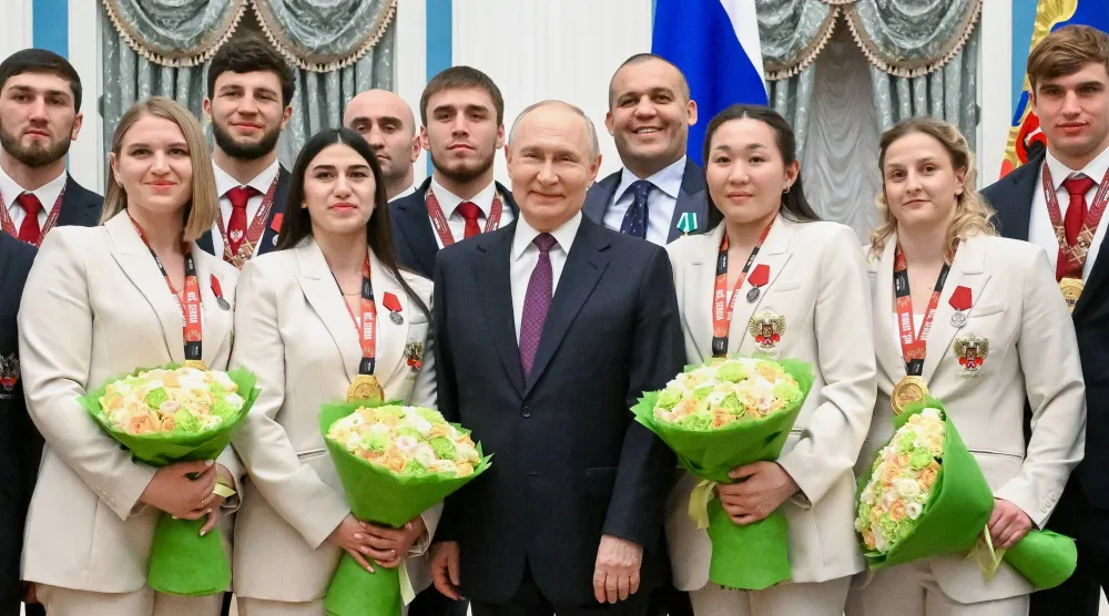 فلاديمير بوتين خلال استقباله لاعبين ولاعبات في بطولة الملاكمة (أ.ب)