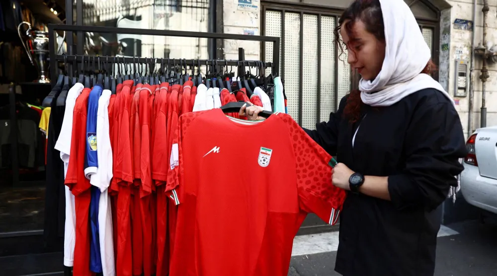 إيرانية تعاين قميص منتخب بلادها بأحد متاجر طهران (رويترز)