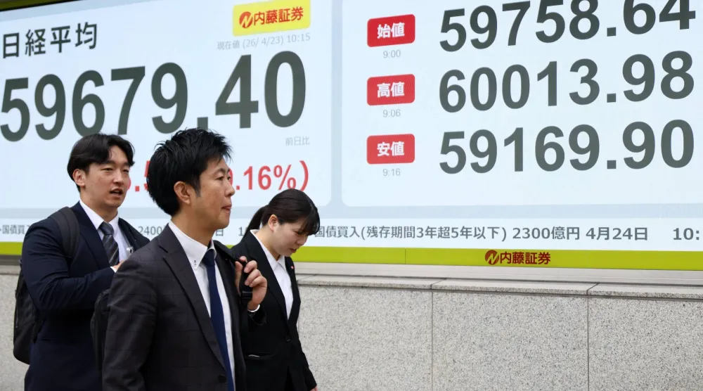 مشاة يمرون أمام شاشة تعرض حركة الأسهم في العاصمة اليابانية طوكيو (إ ب أ)