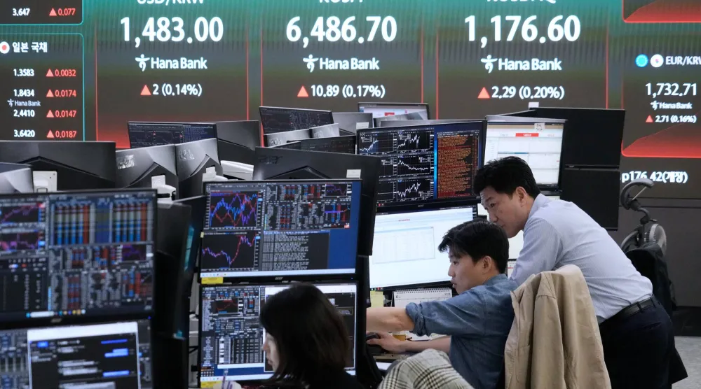 متداولون يتابعون الشاشات في غرفة تداول العملات الأجنبية بالمقر الرئيسي لبنك هانا في سيول (أ ب)