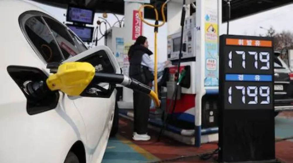 امرأة تملأ سيارتها بالنزين داخل محطة وقود في سيول (رويترز)