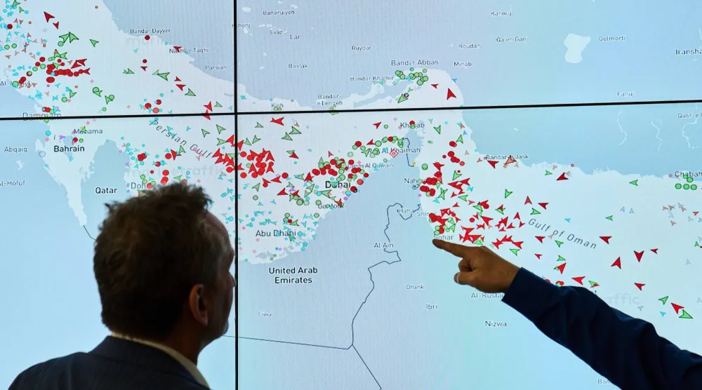 Hapag-Lloyd employees monitor the status of cargo ships in the Strait of Hormuz on a screen, in Hamburg, Germany, Wednesday, April 15, 2026. (AP Photo/Ebrahim Noroozi)