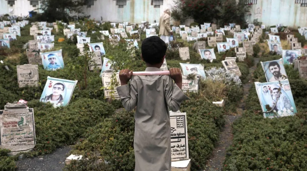 طفل يمني يزور مقبرة لقتلى الحوثيين في صنعاء (إ.ب.أ)
