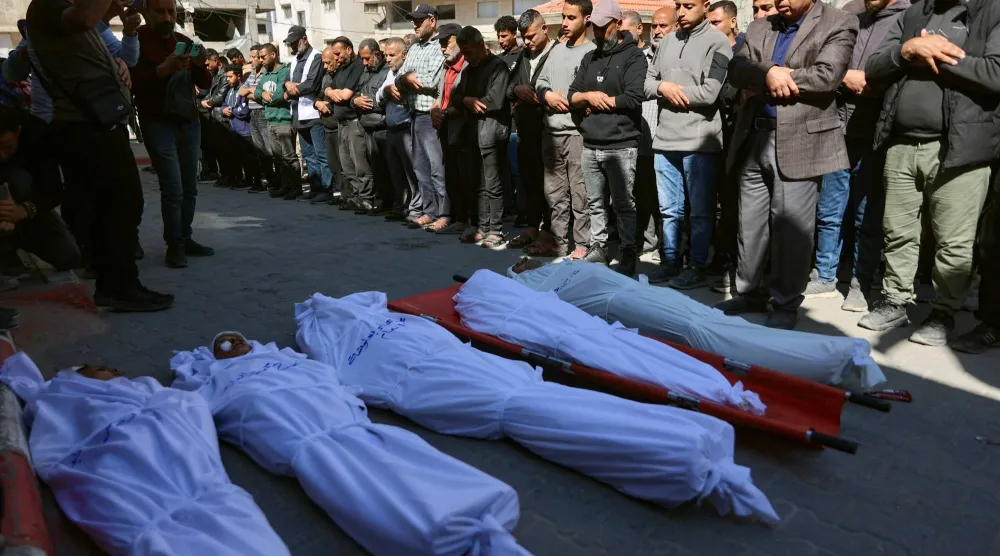 فلسطينيون يشيعون قتلى سقطوا في هجوم إسرائيلي أمام مستشفى الشفاء بمدينة غزة الخميس (أ.ف.ب)