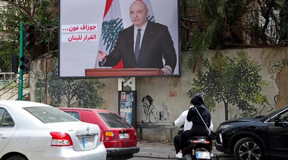 شعار مؤيد لقرارات الرئيس اللبناني جوزيف عون مكتوب على صورة عملاقة له في أحد شوارع بيروت (أ.ف.ب)
