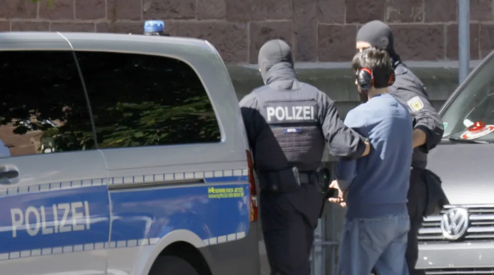 ضباط من الشرطة الفيدرالية الألمانية يرافقون مشتبَهاً به إرهابياً من مروحية إلى المحكمة الفيدرالية العليا في كارلسروه (أرشيفية-إ.ب.أ)