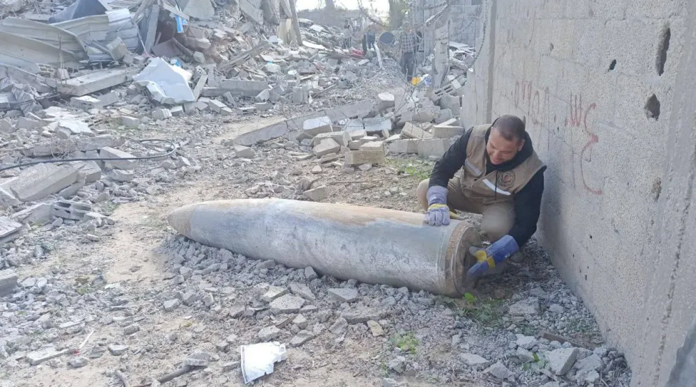 أحد عناصر هندسة المتفجرات التابعة لشرطة غزة يتعامل مع قذيفة غير منفجرة (الشرطة الفلسطينية)