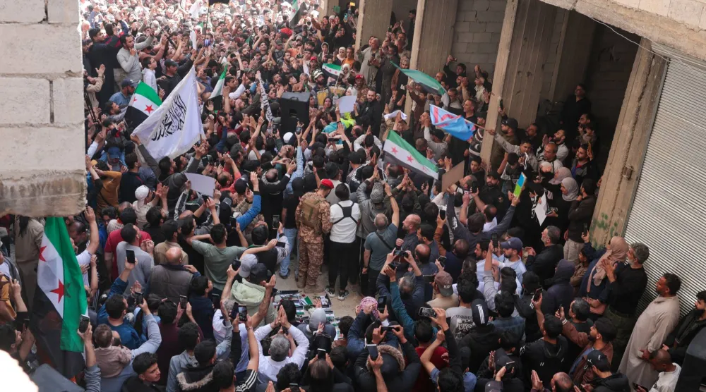 سوريون يحتفلون بالقبض على المتهم بارتكاب «مجزرة التضامن» في حي التضامن بدمشق الجمعة (إ.ب.أ)