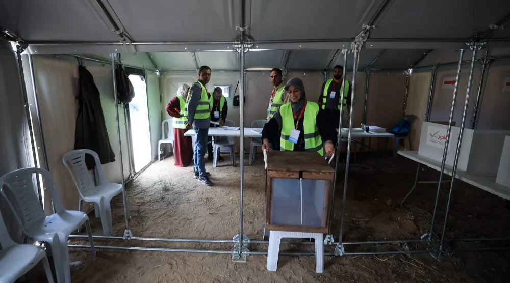أقام مسؤولون انتخابيون فلسطينيون مركز اقتراع في خيمة لإجراء الانتخابات البلدية بدير البلح (أ.ف.ب)