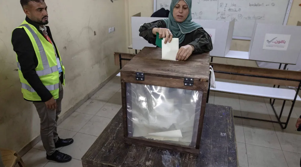 فلسطينية تدلي بصوتها داخل مركز اقتراع في دير البلح وسط قطاع غزة السبت (إ.ب.أ)