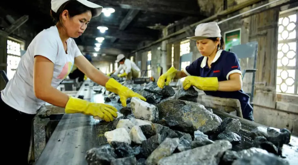 عمال يعملون في مصنع للتعدين في تشونغشان الصينية (رويترز)