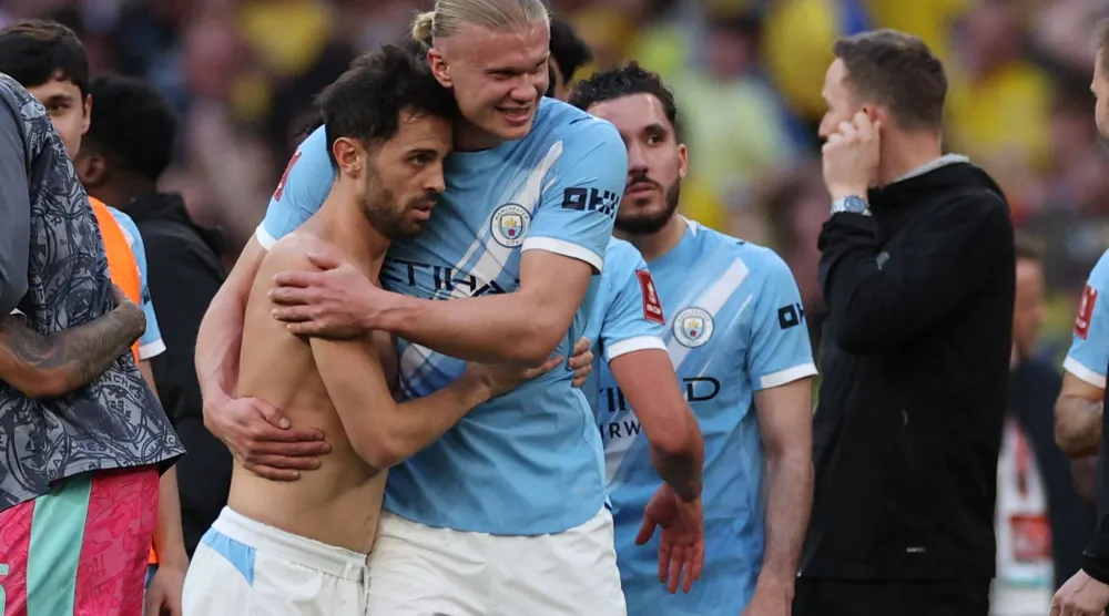 هالاند يحتفل مع سيلفا بالتأهل (أ.ف.ب)