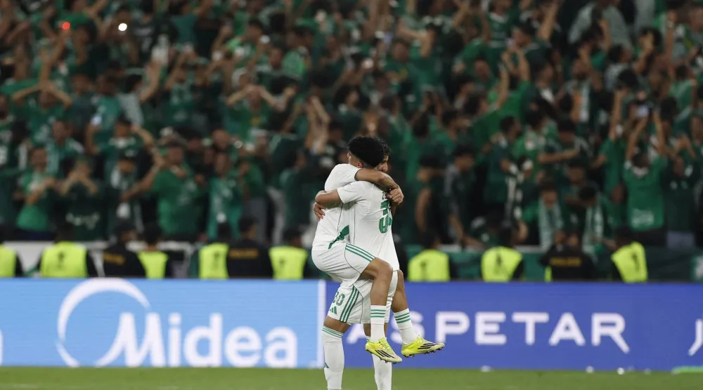 لاعبا الأهلي يحتفلان أمام جماهيرهما باللقب الآسيوي (رويترز)