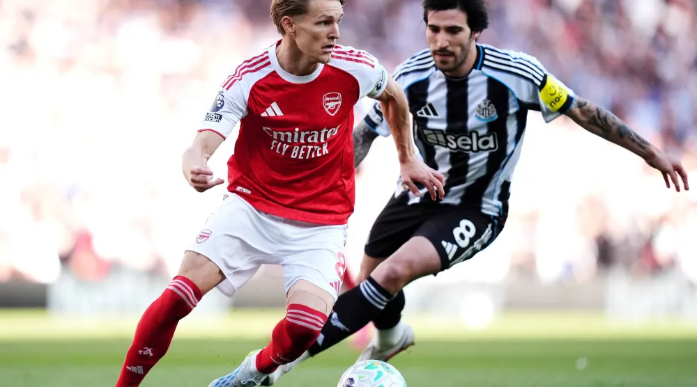 لاعب آرسنال مارتن أوديغارد يصارع على الكرة مع لاعب نيوكاسل يونايتد ساندرو تونالي (د.ب.أ)