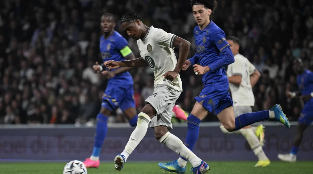 لاعب وسط تولوز السنغالي بابي ديمبا ديوب يمرر الكرة أمام لاعب وسط موناكو ماغنيس أكليوش (أ.ف.ب)