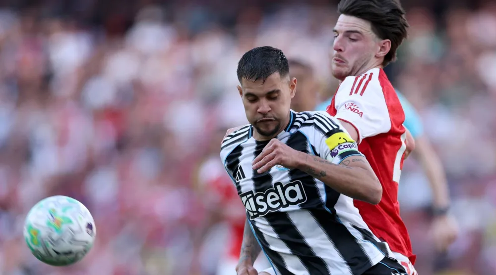 لاعب نيوكاسل يونايتد برونو غيماريش يتنافس على الكرة مع لاعب أرسنال ديكلان رايس (أ.ب)