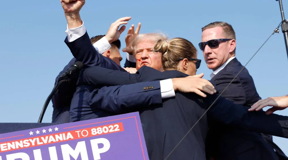 نقل دونالد ترمب إلى خارج المسرح بعد محاولة اغتياله خلال تجمع حاشد في باتلر بولاية بنسلفانيا في يوليو 2024 (أ.ف.ب)