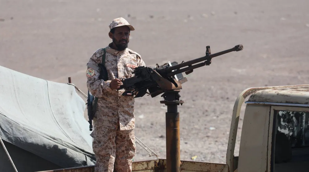 جندي يمني يمسك رشاشاً على متن عربة عسكرية بالقرب من باب المندب (رويترز)