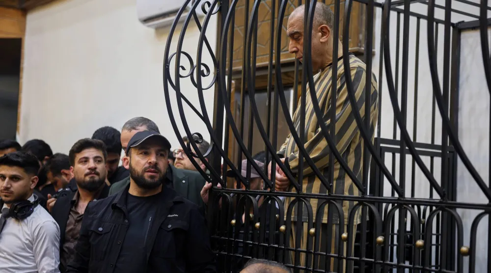 عاطف نجيب الرئيس السابق لفرع الأمن السياسي في منطقة درعا خلال حكم بشار الأسد في قفص الاتهام خلال جلسة محاكمة في قصر العدل بدمشق سوريا اليوم الأحد (أ.ب)